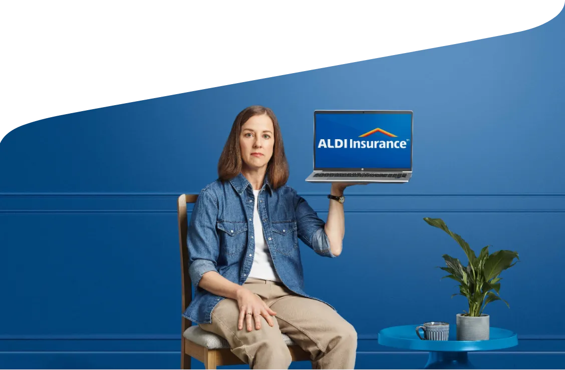 A woman holding a laptop displaying ALDI Insurance.