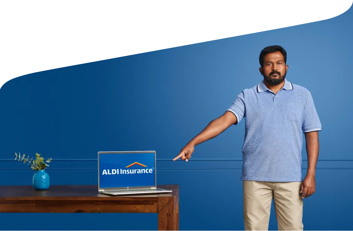 A man pointing at a laptop displaying ALDI Insurance.