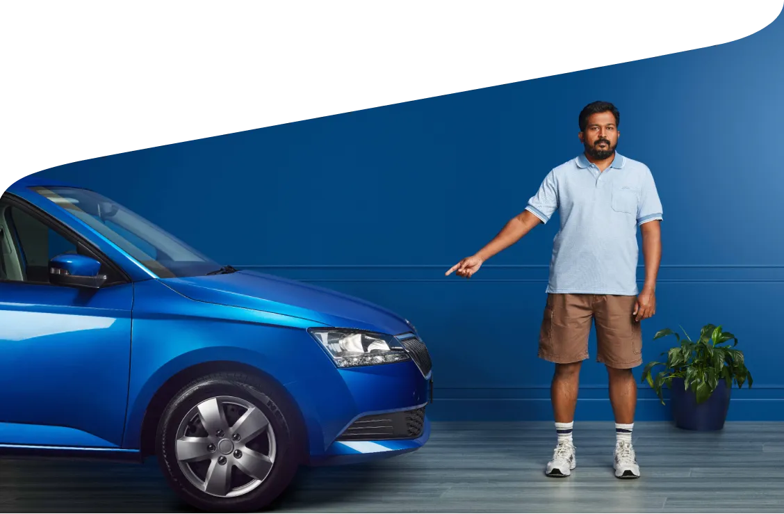 A man pointing at a blue car.