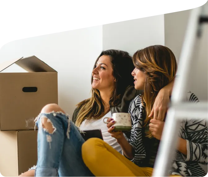 Two women takeing a break while unpacking boxes.